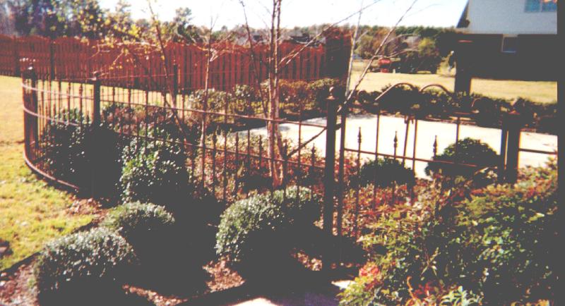 ornamental iron walkway gate and curved fence