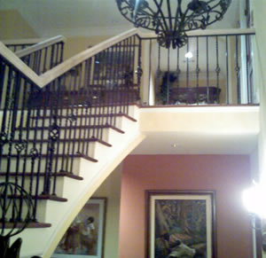 curved wood handrail on a wrought iron stairway railing